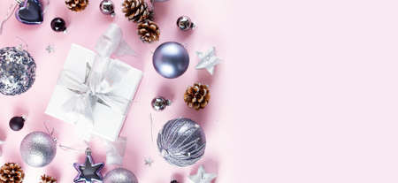 Gray Christmas decorations with gift box on pink background, top view web bannerの写真素材