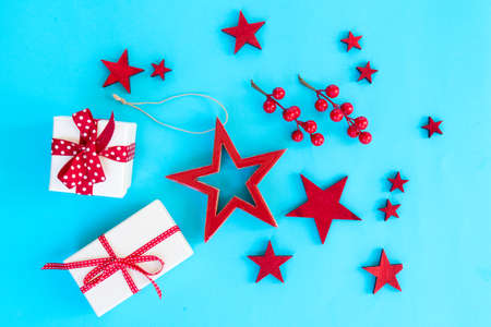 Christmas flat lay scene with stars and christmas gift boxes on aqua blue background