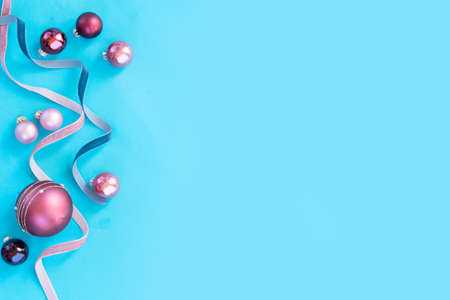 Christmas flat lay scene with festive ribbons and balls christmas decorations on all aqua blue background with copy spaceの写真素材