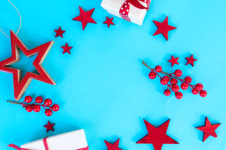 Christmas flat lay scene with stars and gift box on aqua blue background, top view frame