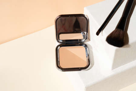 Minimal modern cosmetic scene with make up brushes, powder, neutral beige colors