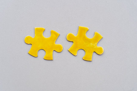 two jigsaw illuminating yellow puzzles pieces on ultimate gray backgroundの写真素材
