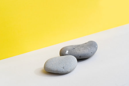 Minimal modern product display on textured gray and yellow background with shadowsの写真素材
