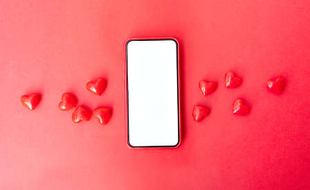 Modern phone with hearts, social distancing and dating concept, valentines day mock up, copy space on displayの写真素材