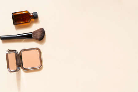 Minimal modern cosmetic scene with make up brushes, powder, foundation cream over nude backgroundの写真素材