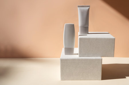 Minimal modern cosmetic products display with two tubes on beige background with copy spaceの写真素材