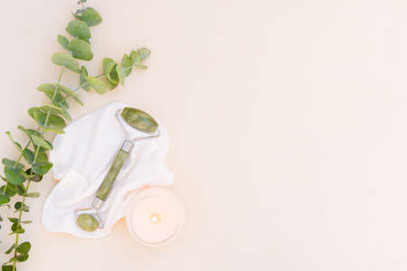 gua sha, face massage green jade roller made of natural stone with natural eucaliptusの写真素材
