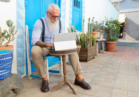 Senior hipster man working on a modern laptop, happiness, technology and elderly lifestyle people...