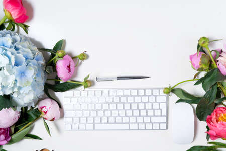 Creative wedding composition with keyboard mock up, flowers on blue desk background. Flat lay, top...