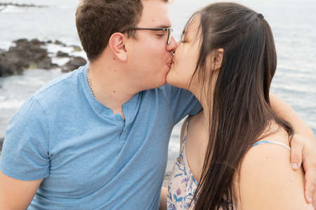 Couple in love kissing each other while spending time outdoors on seasideの写真素材