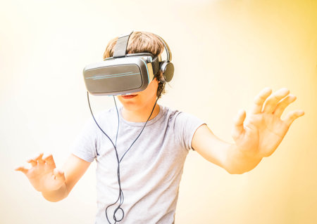 Teenager boy wearing and touching something in VR virtual realty glasses, modern people and technology lifestyleの写真素材