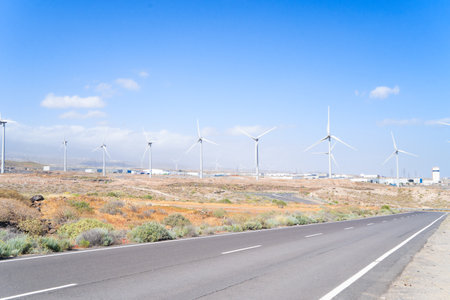 Wind energy concept - road leading to the wind turbines farm