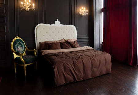 view of bed with beaige linen and burgundy pillows close upの写真素材