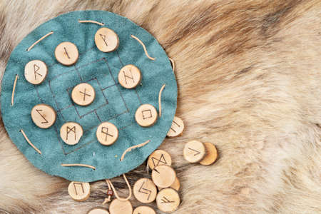 Handmade runes for fortunetelling over green leather chartの写真素材