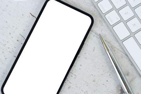Desk mock up with modern phone, close up top view with copy spaceの写真素材