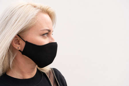 Blond smiling happy in mask, copy space on the wall, happy life and relaxation during coronavirus...