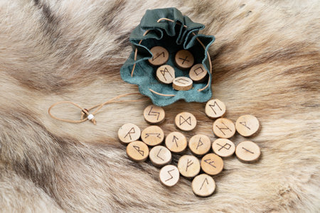 Handmade runes for fortunetelling in leather bag over wolf fur
