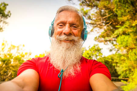 Senior using mobile phone outdoor - Hipster mature man having fun with new trends, smartphone apps -...