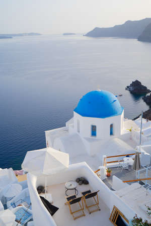 traditional greek village Oia of Santorini, with blue domes of churches and deep sea view, Greece