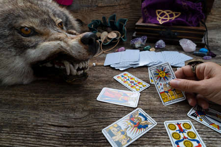 Fortune telling on tarot cards, witch hand is holding on of cards, used Marseille Tarot deck by unknown artist published first in 1709の写真素材