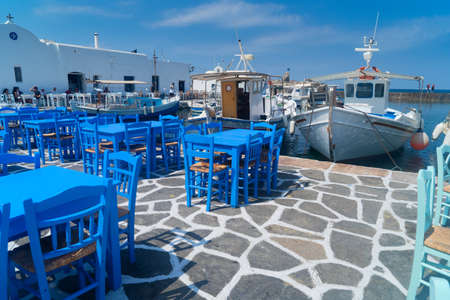 Naoussa village with mooring boats and blue cafe tables