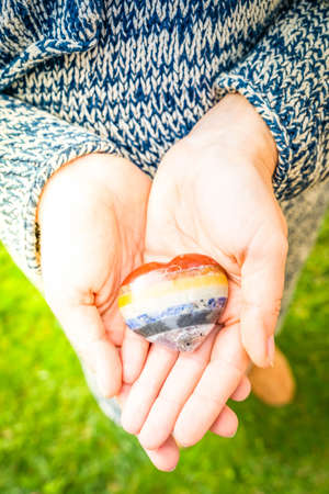 Hand holding set of chakra stones in heart shape. Magic healing Rock for Reiki Crystal Ritual,...