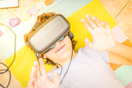 Teenager wearing VR virtual realty black glasses in home close up, modern people and technology...