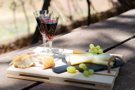 picnic with red wine bottle and glasses, bread and cheese