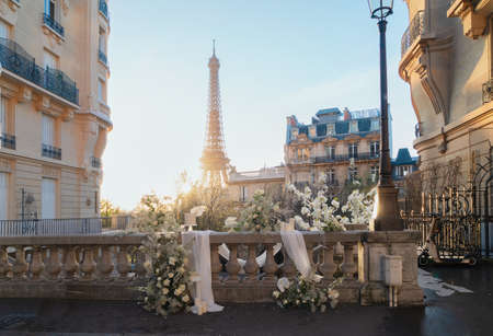 cosy Paris street with view on the famous Eiffel Tower on spring day with white flowers decorations, Paris Franceの写真素材