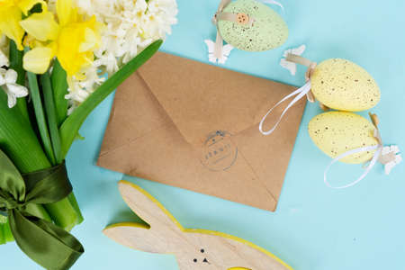 Easter scene with fresh spring flowers and colored eggs, flat lay on blue backgroundの写真素材