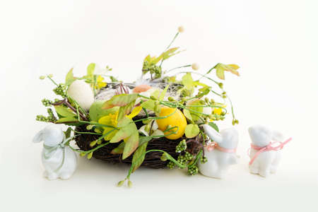 Easter scene with colored eggs in nest with tulips and bunny