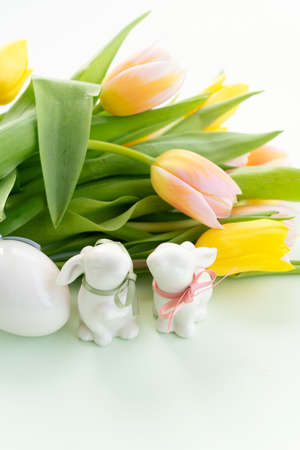 Easter Egg hunt with two Easter white bunnies an tulipsの写真素材