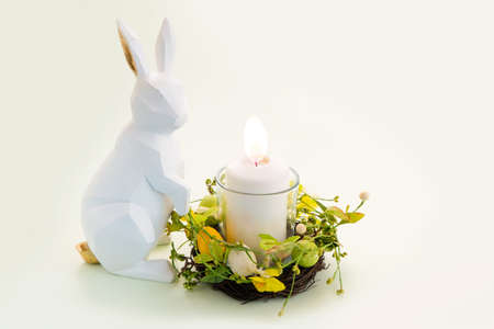 Easter scene with colored eggs in nest with candle and bunnyの写真素材