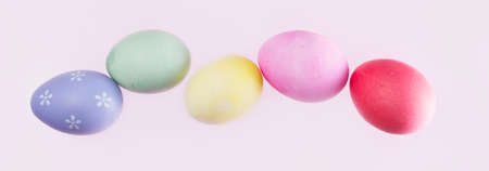 Row of flying easter eggs on pink backgroundの写真素材