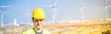 Wind energy concept, engineer standing in front of wind turbines , green energy and eco friedly...