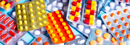 Pile of medical pills and capsules on blue background