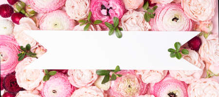 Flowers composition. Pattern made of roses and ranunculus flowers on pink background. Flat lay, top view with copy space on white bannerの写真素材