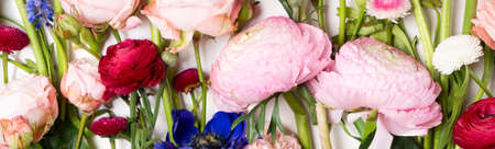 Flowers composition made of roses, ranunculus, pansies and orchids flowers on white background. Flat...