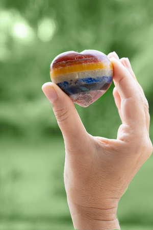 Hand holding set of ÐºÑÑÑÐ¸ÑÑ chakra stones in heart shape. Magic healing Rock for Reiki Crystal Ritual, Witchcraft, spiritual esoteric practiceの写真素材