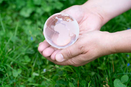 earth protection and sustainable ecology development concept - hands holding planet earth with sprout, africa and EU Europe sideの写真素材