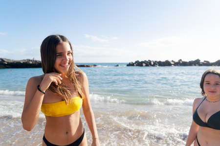 two happy teenager girls having fun on the summer beach - friendsheep and youth conceptの写真素材