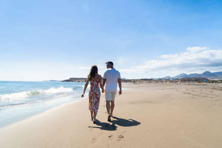 Happy young couple at the sea vacations, man and woman walking at the sea shore close up, vacations and honeymoon conceptの写真素材
