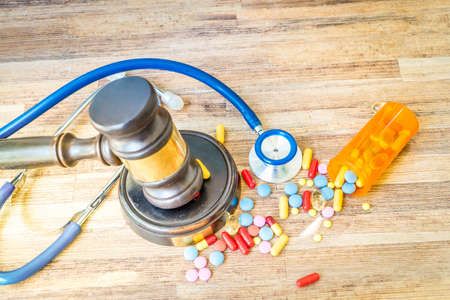 view of law gavel with pills over wooden table, medical law conceptの写真素材
