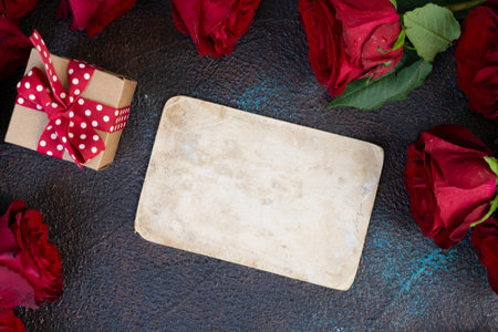Crimson red rose flowers bouquet with gift box and epmty car for text, Valentines Day background