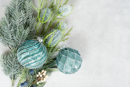 Cristmas silver and teal evergreen tree and winter flowers and glass decorations close up over gray backgroundの写真素材
