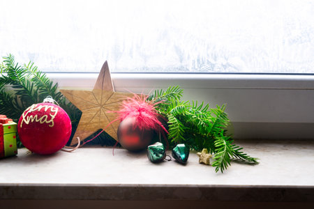 Christmas red and green decorations with Christmas star on windowsil