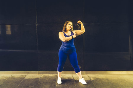 Woman and sports, exercise for weight loss in the fresh air. Poertrait of happy curvy woman doing workout routine, tonedの写真素材