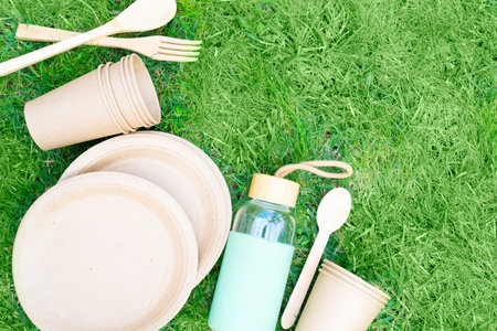 Zero waste concept, disposable tableware over green grassの写真素材