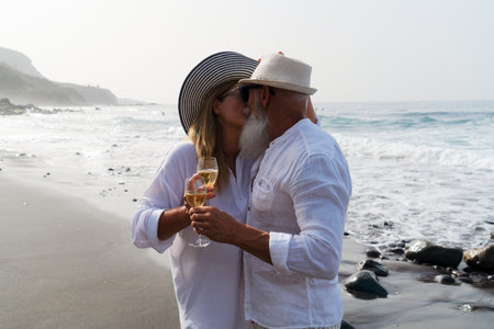 lifestyle of caucasian senior couple drinking champagne on beach, happy in love romantic and relax time, tourism of elderly family pleople, leisure and activity travel after retirementの写真素材