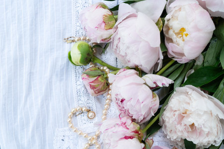 Fresh peonies flowers over lace background, close up view, summer backgroundの写真素材